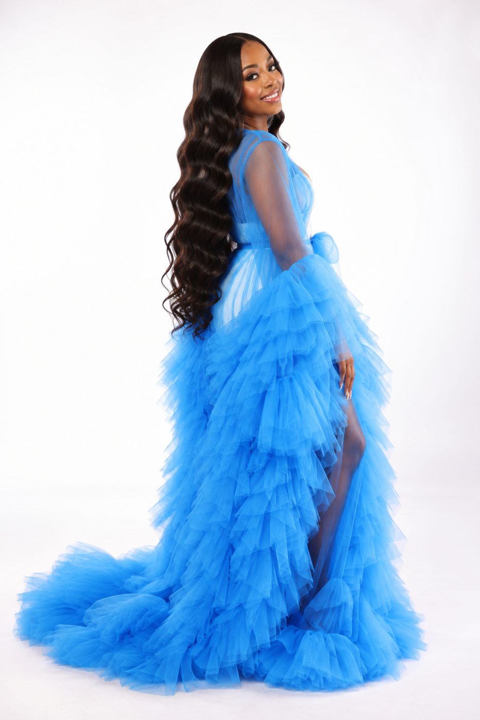 Full-length studio shot of the model in the blue tulle gown with long wavy hair