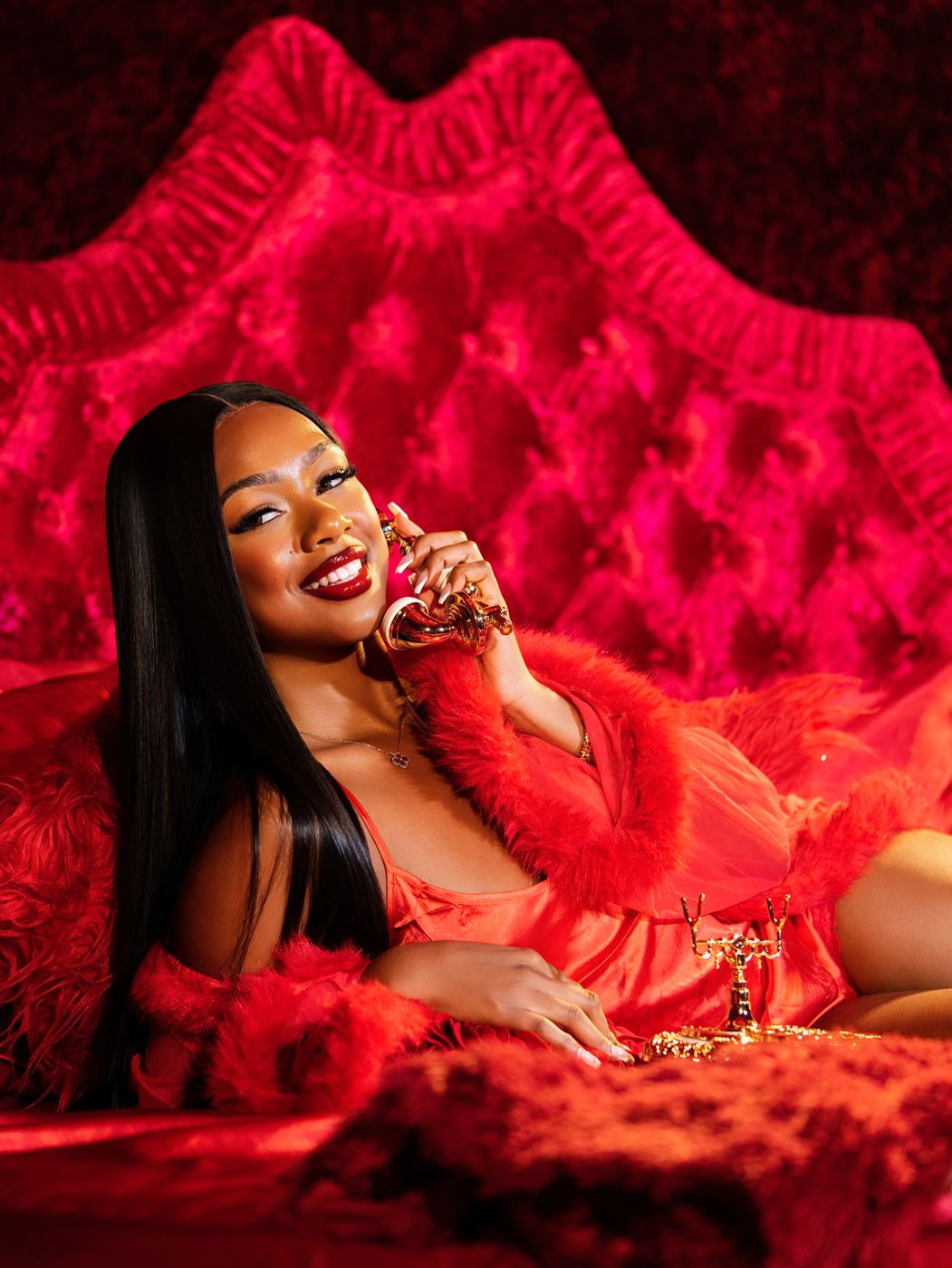 BAIBE OFFICIAL campaign: model in red on a pink velvet bed, smiling on a gold phone
